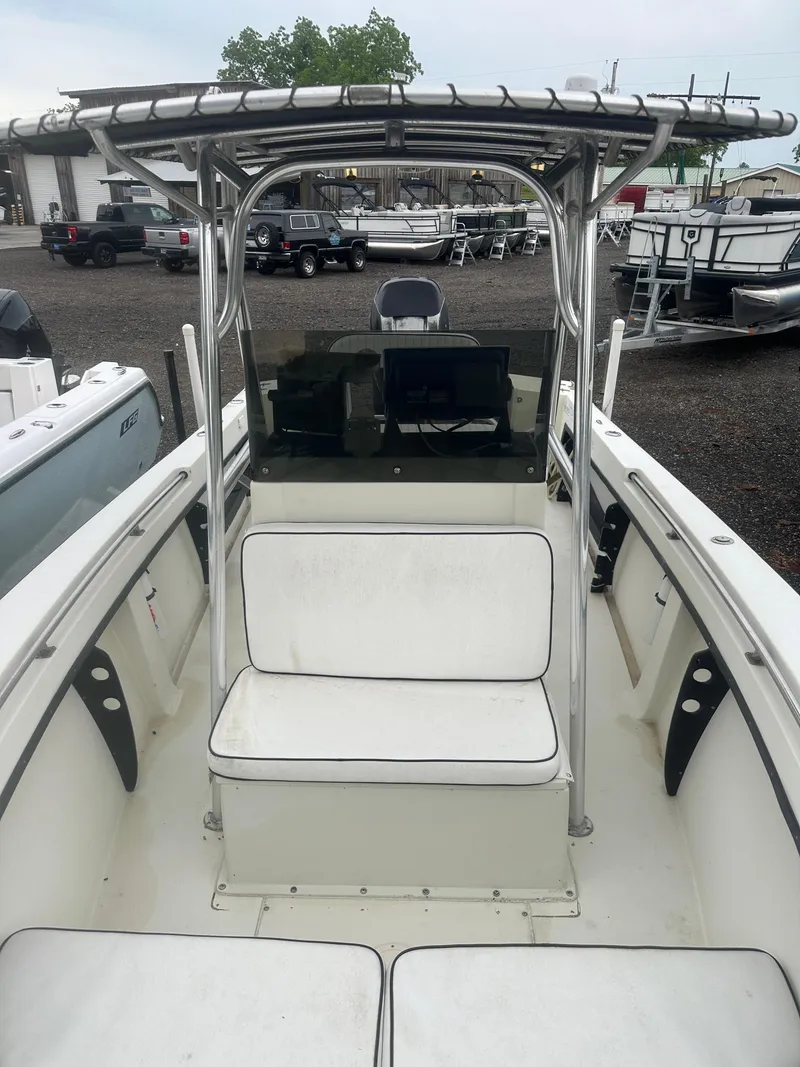 Slide: The Image of 1985 SeaCraft 23 CC boat with T-top and seating, displayed in a marina. - 12