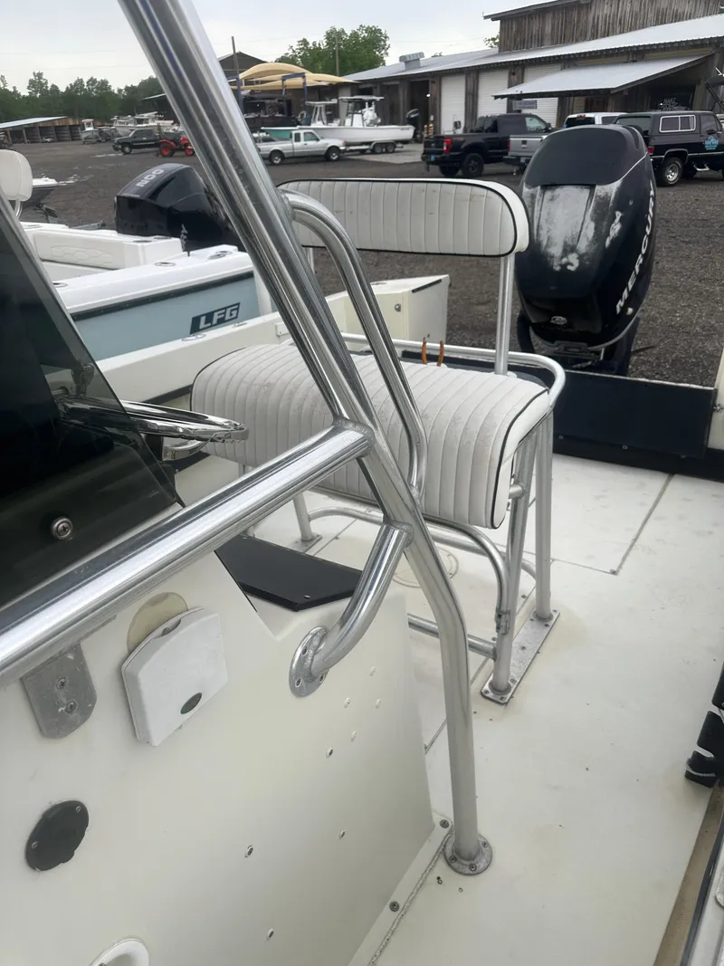 Slide: The Image of 1985 SeaCraft 23 CC boat interior with seating and outboard motor in a marina setting. - 14