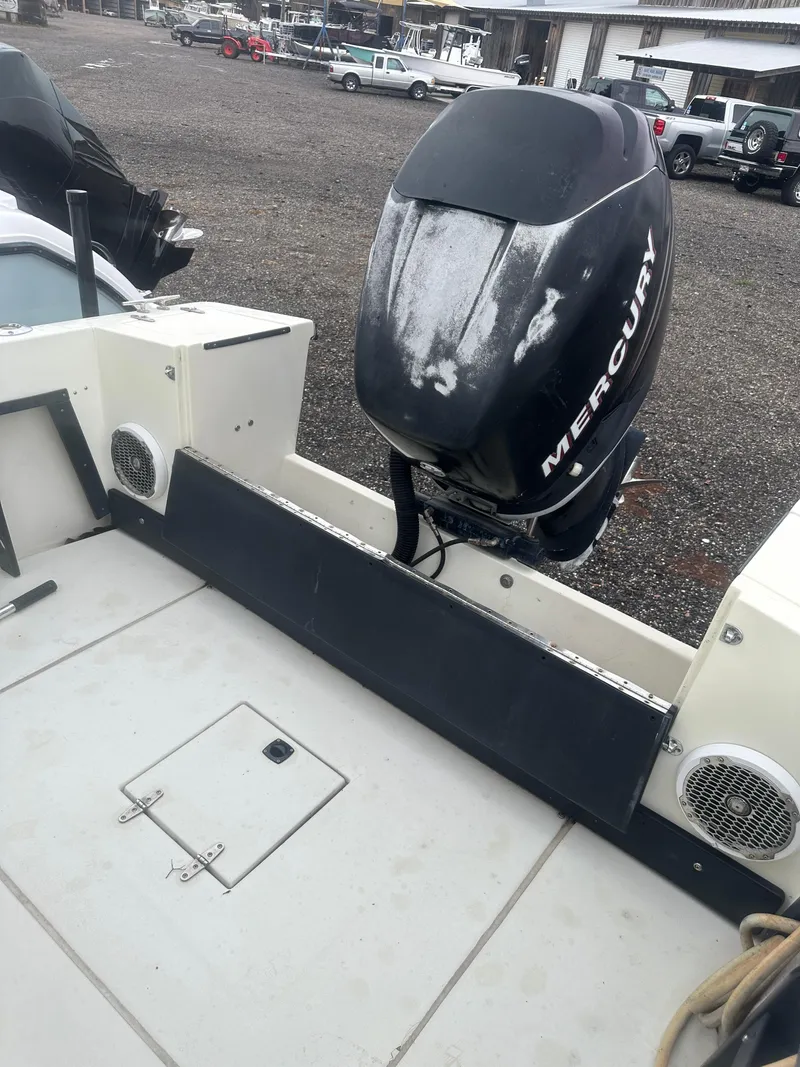 Slide: The Image of 1985 SeaCraft 23 CC boat with Mercury outboard motor, docked on gravel surface. - 15