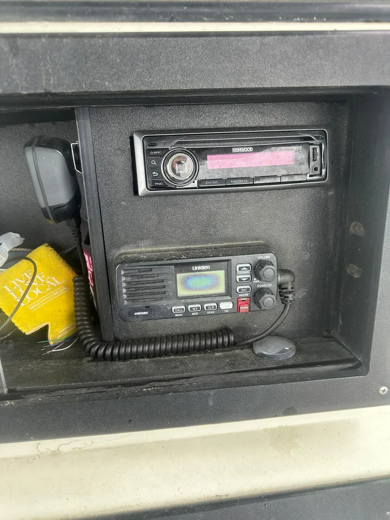 Slide: The Image of 1985 SeaCraft 23 CC dashboard with Kenwood stereo and Uniden marine radio. - 18