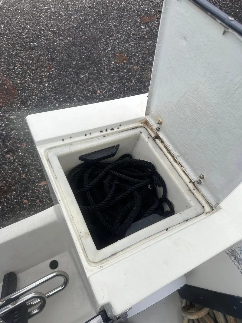Slide: The Image of Open storage compartment on 1985 SeaCraft 23 CC boat with coiled black rope inside. - 19
