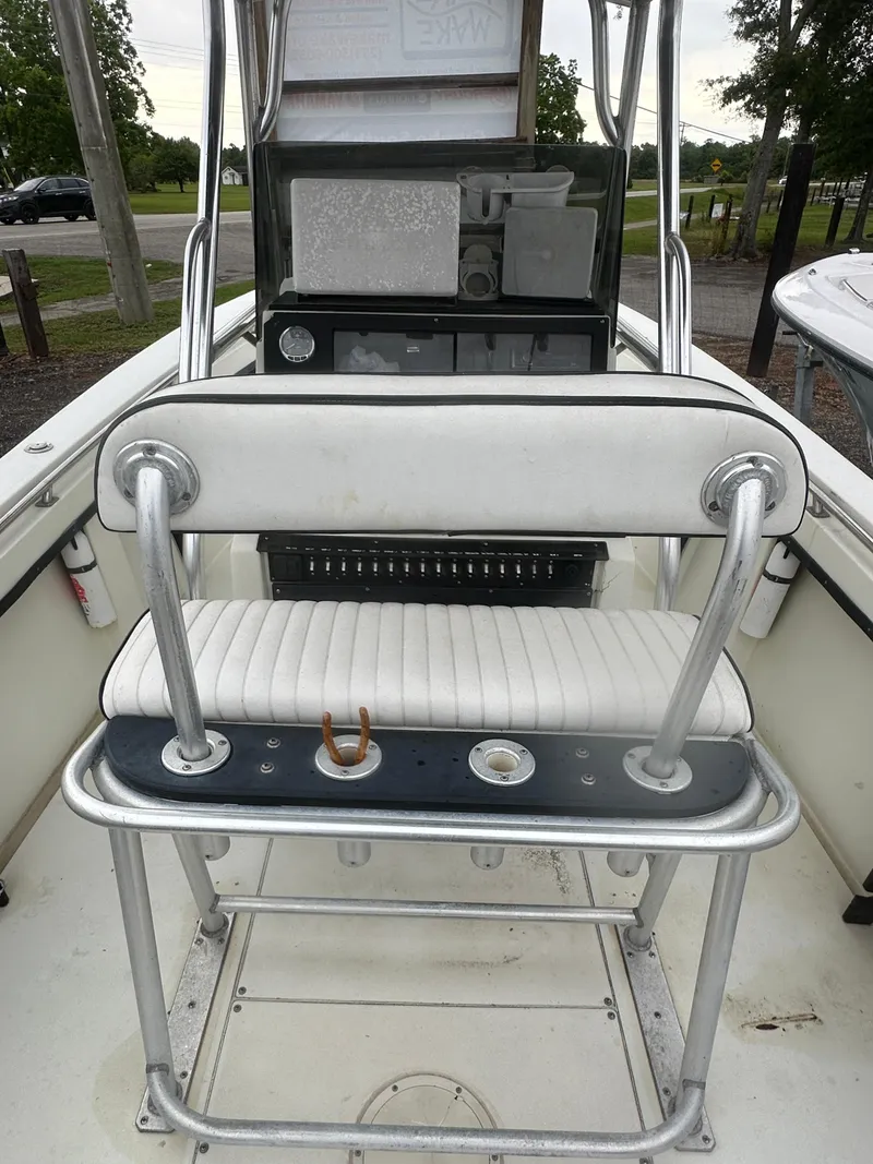 Slide: The Image of 1985 SeaCraft 23 CC boat interior with white seating and control panel. - 21