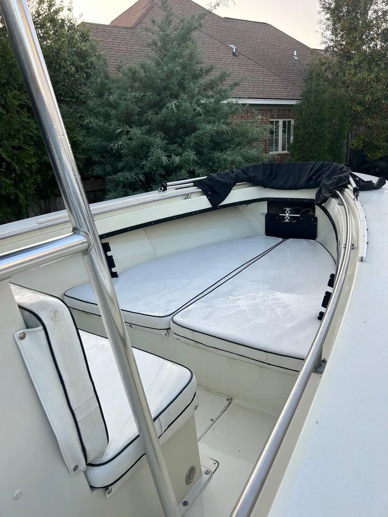 Slide: The Image of 1985 SeaCraft 23 CC boat with white seating, outdoor setting, and lush greenery. - 3