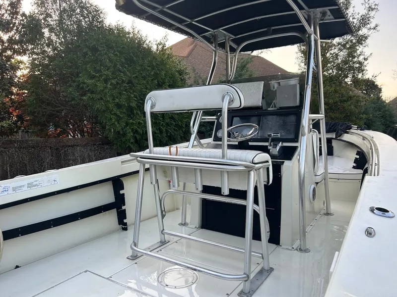 Slide: The Image of 1985 SeaCraft 23 CC boat with center console and seating, surrounded by greenery. - 5