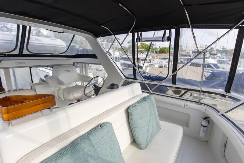 Slide: The Image of 1997 Carver 445 Aft Cabin Motor Yacht interior with helm, seating, and marina view. - 15
