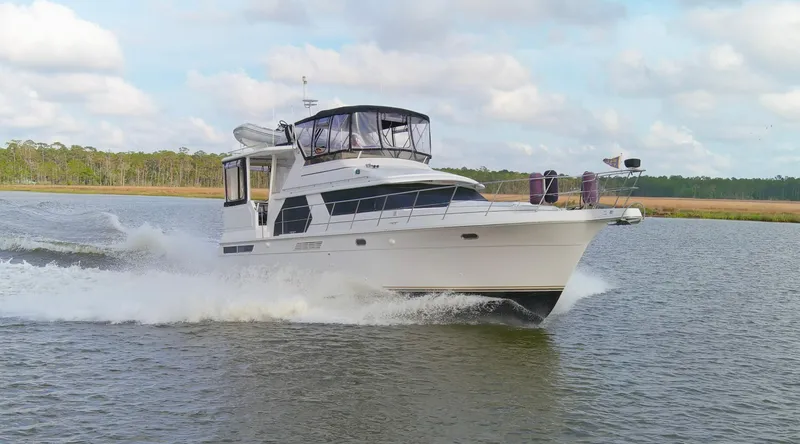 Slide: The Image of 1997 Carver 445 Aft Cabin Motor Yacht cruising on a calm river. - 19