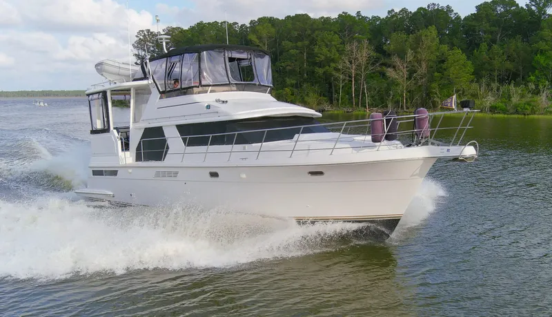 Slide: The Image of 1997 Carver 445 Aft Cabin Motor Yacht cruising on a scenic river. - 25