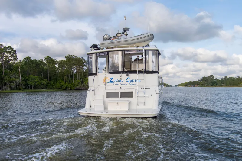 Slide: The Image of 1997 Carver 445 Aft Cabin Motor Yacht cruising on a scenic waterway. - 29