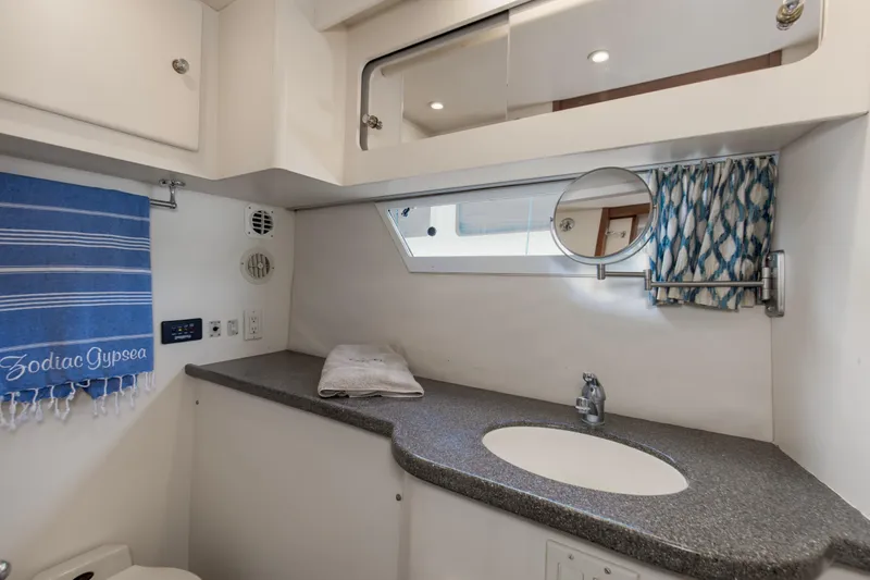 Slide: The Image of 1997 Carver 445 Aft Cabin Motor Yacht bathroom with sink, mirror, and blue towel. - 9