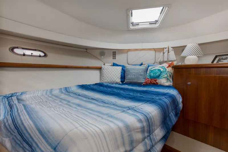 Slide: The Image of 1997 Carver 445 Aft Cabin Motor Yacht bedroom with blue bedding and nautical decor. - 11
