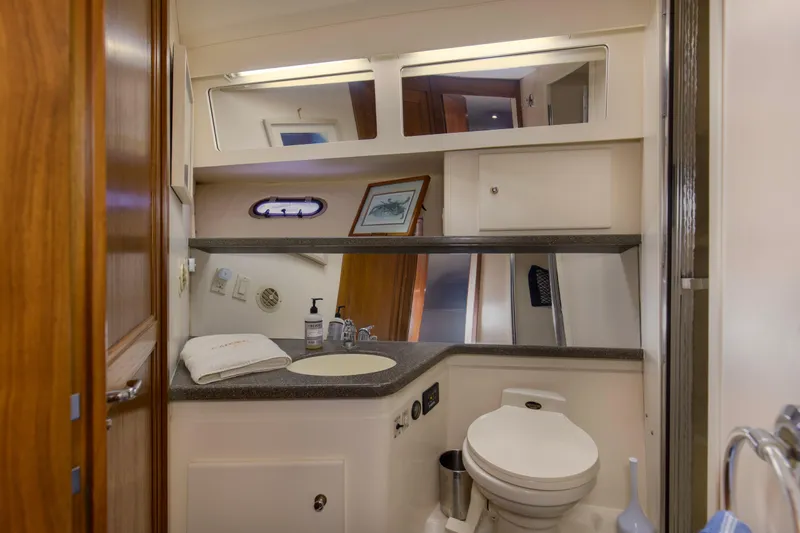 Slide: The Image of 1997 Carver 445 Aft Cabin Motor Yacht bathroom with mirror, sink, and toilet. - 12