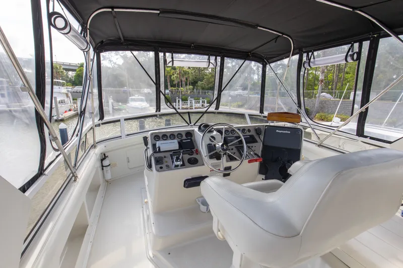 Slide: The Image of 1997 Carver 445 Aft Cabin Motor Yacht helm with steering wheel and navigation equipment. - 14