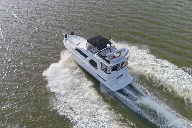 Slide: The Image of Aerial view of 1997 Carver 445 Aft Cabin Motor Yacht cruising on open water. - 24