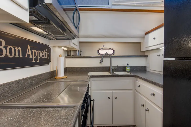 Slide: The Image of 1997 Carver 445 Aft Cabin Motor Yacht kitchen with modern amenities and "Bon Appetit" sign. - 4