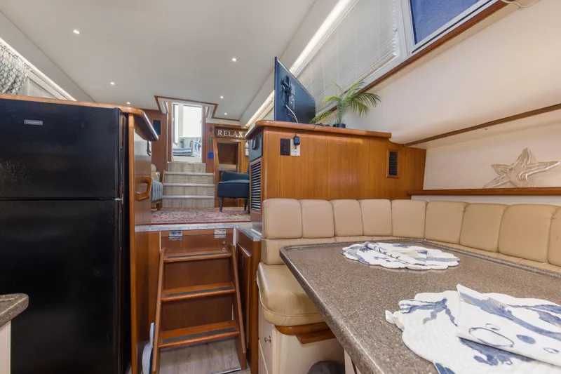 Slide: The Image of Interior of 1997 Carver 445 Aft Cabin Motor Yacht, featuring dining area and stairs. - 6