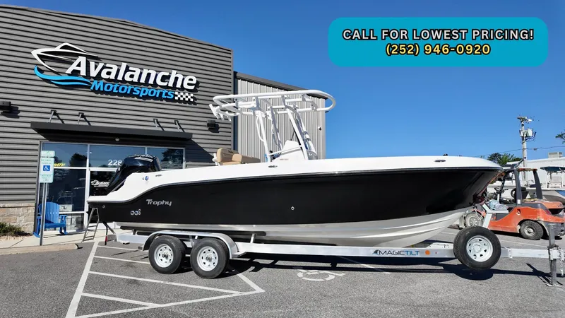 The Image of 2025 Bayliner Trophy 24 CC boat on trailer at Avalanche Motorsports dealership. - 0