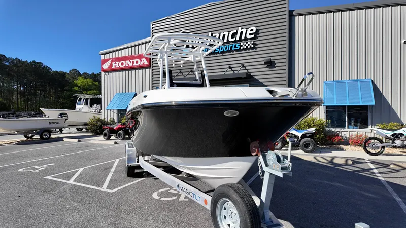Slide: The Image of 2025 Bayliner Trophy 24 CC boat on trailer outside dealership. - 1