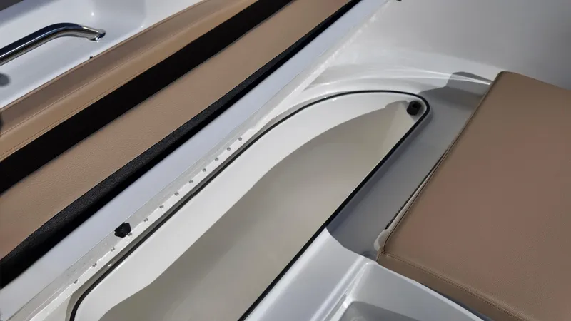 Slide: The Image of 2025 Bayliner Trophy 24 CC interior with beige seating and storage compartment. - 17