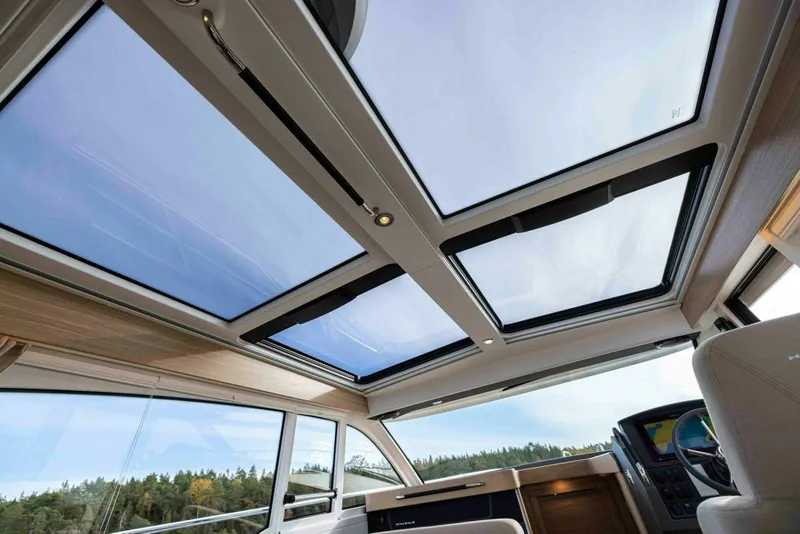 Slide: The Image of 2025 Nimbus 365 Coupe interior with panoramic sunroof and modern dashboard design. - 10