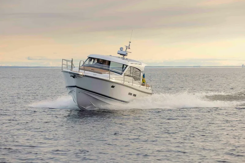 Slide: The Image of 2025 Nimbus 365 Coupe cruising on open water at sunset. - 2