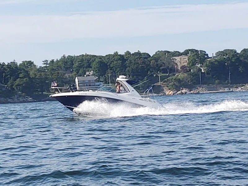 Slide: The Image of 2007 Sea Ray 310 Sundancer cruising on a scenic lake with lush green shoreline. - 0