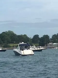 Slide: The Image of 2007 Sea Ray 310 Sundancer boat on water near shoreline with trees and houses. - 1