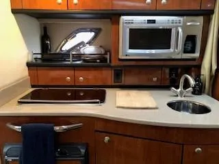 Slide: The Image of 2007 Sea Ray 310 Sundancer galley with microwave, sink, and stove. - 10