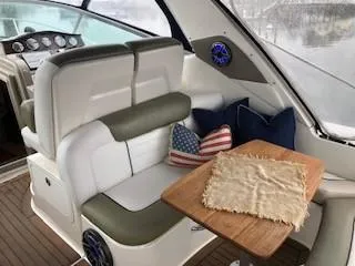 Slide: The Image of 2007 Sea Ray 310 Sundancer interior with plush seating, wooden table, and decorative cushions. - 13