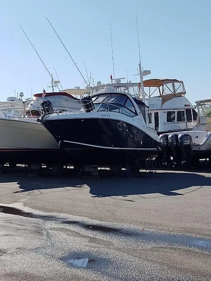 Slide: The Image of 2007 Sea Ray 310 Sundancer boat docked with other vessels under clear sky. - 14