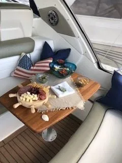 Slide: The Image of 2007 Sea Ray 310 Sundancer interior with snacks on a wooden table, nautical-themed decor. - 17