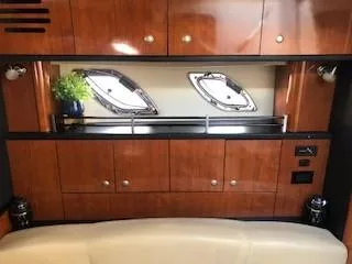 Slide: The Image of 2007 Sea Ray 310 Sundancer interior with wood cabinets and porthole windows. - 4