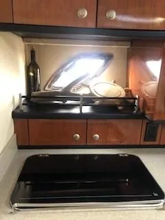 Slide: The Image of 2007 Sea Ray 310 Sundancer kitchen with wooden cabinets and a sleek black stove. - 5
