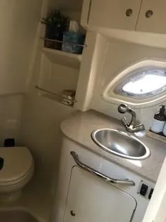 Slide: The Image of 2007 Sea Ray 310 Sundancer bathroom with sink, toilet, and storage shelves. - 8