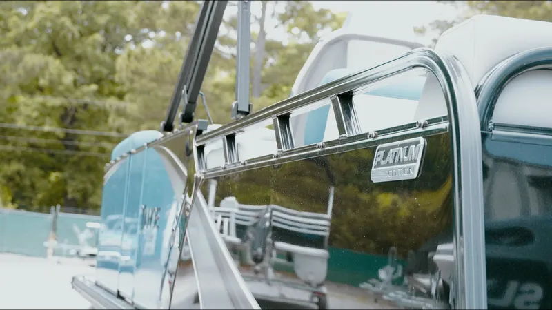 Slide: The Image of 2025 Tahoe Pontoon LTZ Versatile Rear Lounger, sleek design, reflective finish, outdoor setting. - 22