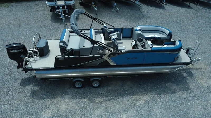 Slide: The Image of 2025 Tahoe Pontoon LTZ Versatile Rear Lounger on trailer, featuring blue and gray seating. - 27