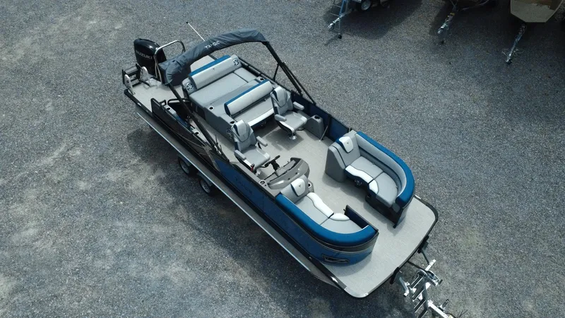 Slide: The Image of 2025 Tahoe Pontoon LTZ Versatile Rear Lounger, aerial view, parked on gravel. - 30