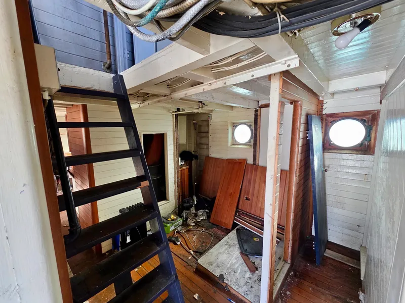 Slide: The Image of Interior of an 1890 custom tugboat, showing wooden stairs and portholes. - 13