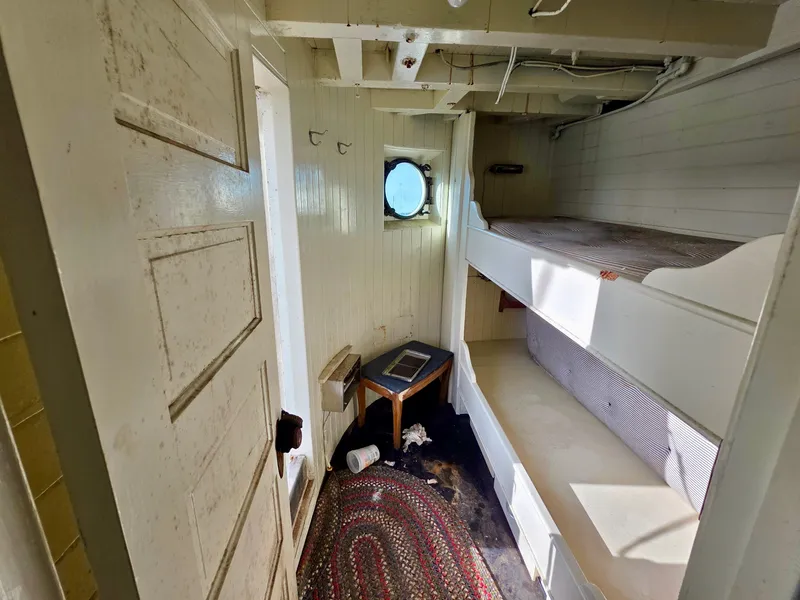 Slide: The Image of Historic 1890 tugboat cabin interior with bunk beds, porthole, and vintage decor. - 14