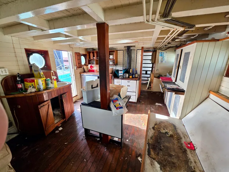 Slide: The Image of Interior of a vintage 1890 custom tugboat with wooden floors and nautical decor. - 16