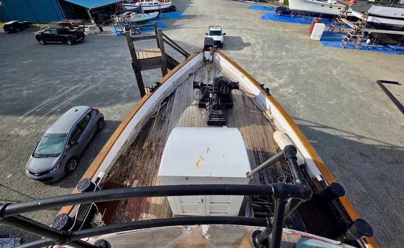Slide: The Image of Old tugboat deck view in a shipyard, surrounded by vehicles and boats. - 19