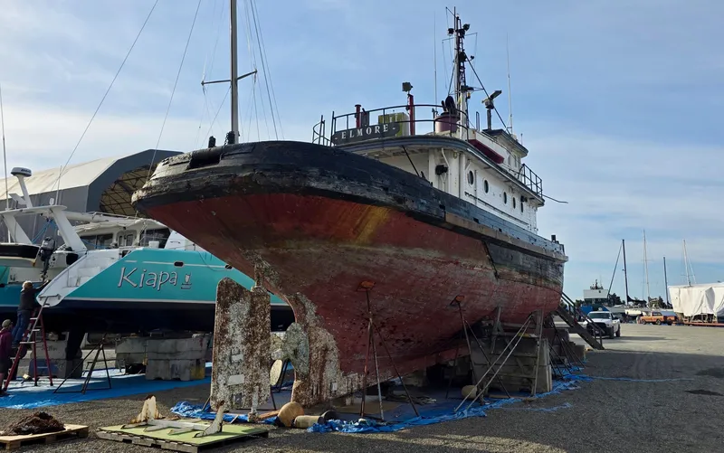 Slide: The Image of Historic 1890 custom tugboat on dry dock, showcasing weathered hull and maritime equipment. - 2