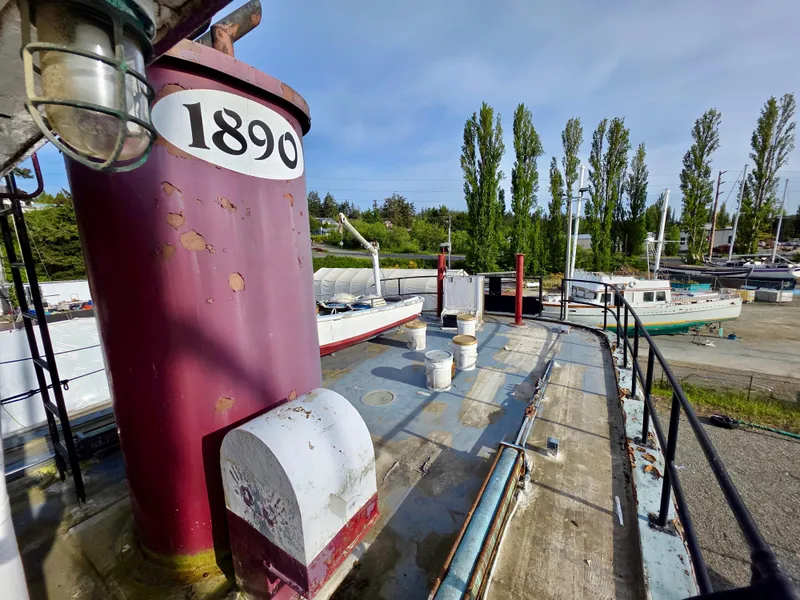 Slide: The Image of Historic 1890 custom tugboat with weathered deck, docked near trees and other boats. - 20