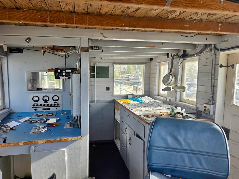 Slide: The Image of Interior of a vintage 1890 custom tugboat with control panel and blue chair. - 24