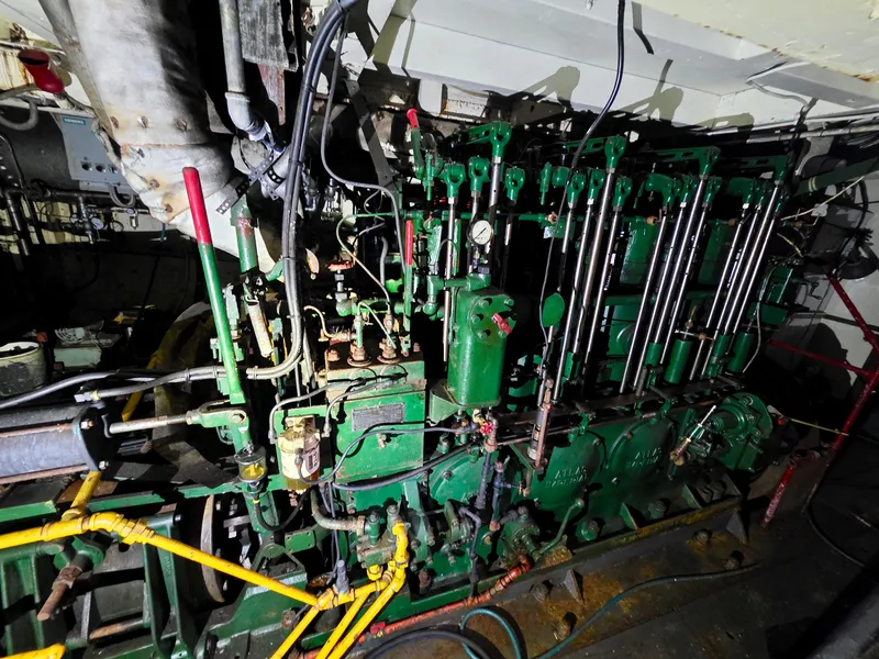 Slide: The Image of Antique 1890 custom tugboat engine with intricate green machinery and pipes. - 26