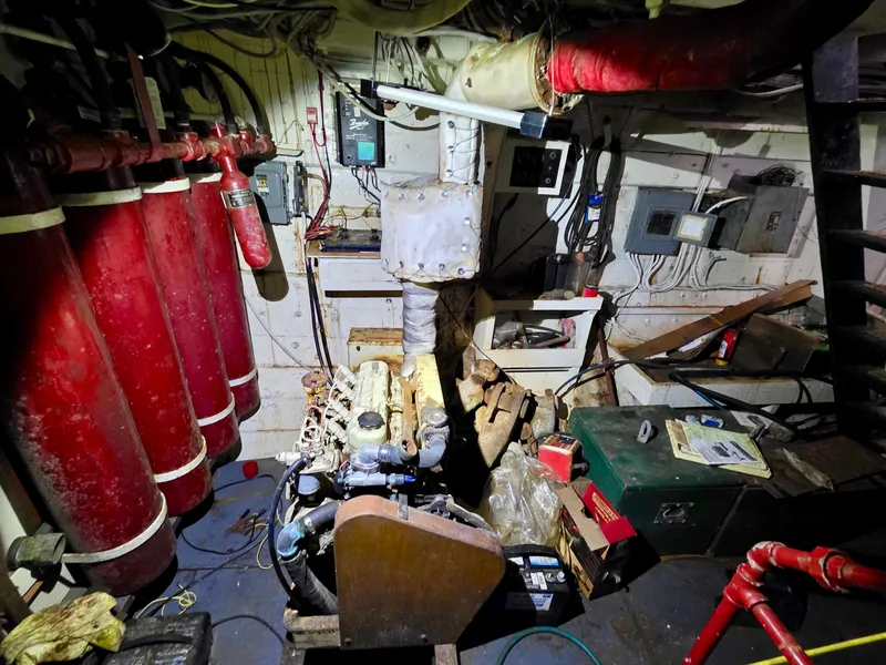 Slide: The Image of Engine room of a vintage 1890 custom tugboat with red fire extinguishers and machinery. - 28