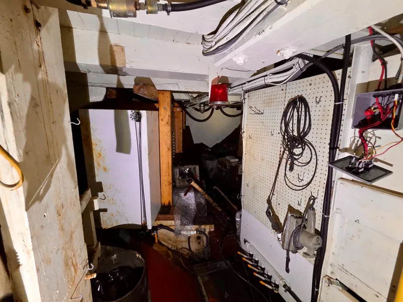 Slide: The Image of Engine room of a vintage 1890 custom tugboat, featuring tools and wiring. - 32
