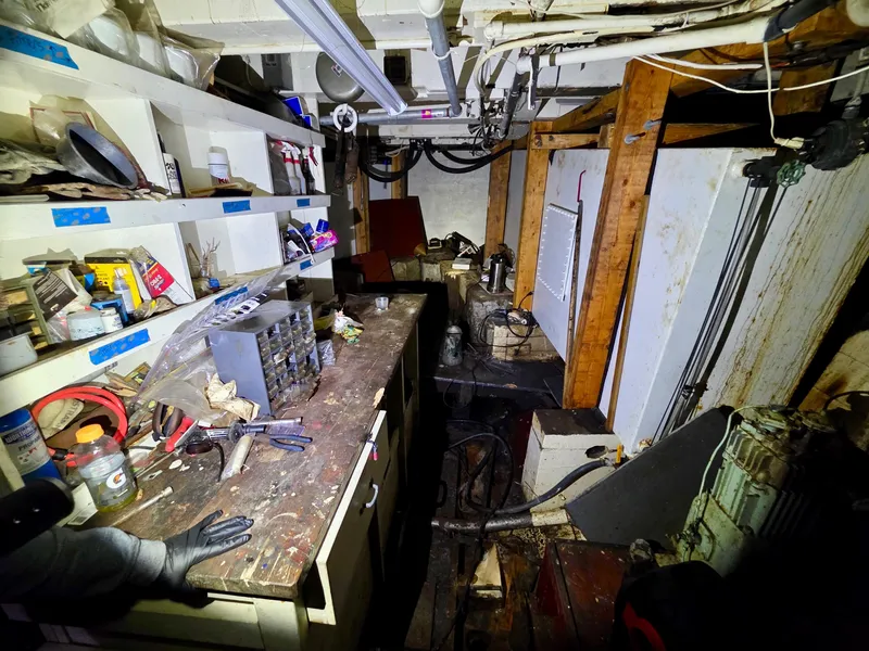 Slide: The Image of Cluttered workshop inside a vintage 1890 custom tugboat, featuring tools and equipment. - 33