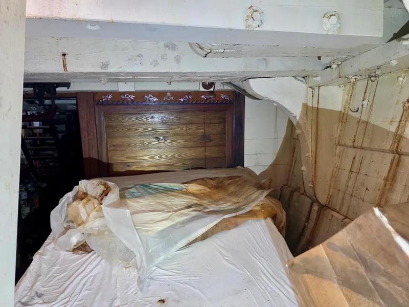 Slide: The Image of Interior of an 1890 custom tugboat with wooden paneling and covered furniture. - 35