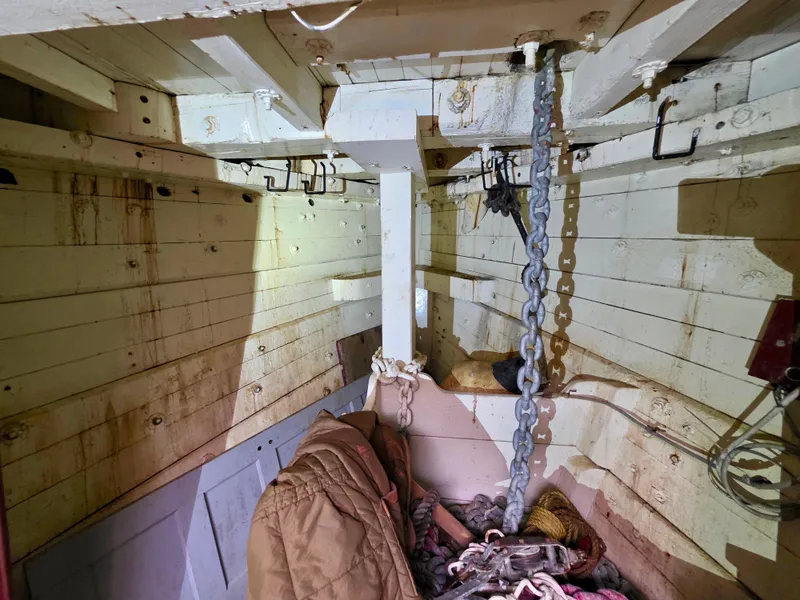 Slide: The Image of Interior of an 1890 custom tugboat with chains and ropes in a wooden compartment. - 39