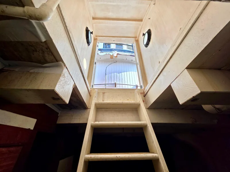 Slide: The Image of Interior view of an 1890 custom tugboat, featuring a wooden ladder and portholes. - 41